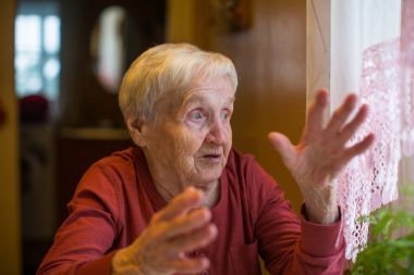 Konuşmak ve elleriyle işaret duygusal yaşlı kadın.