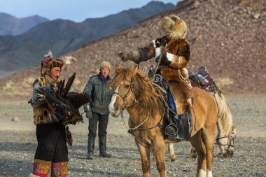 Sagsay, Moğolistan - 28 Eylül 2017: Bayan-Olgii Aymağı dağlarında bir Altın Kartallar ile tavşan kızı avcılık için kazak kartal Hunter (Berkutchi) atı ile öğretir. 