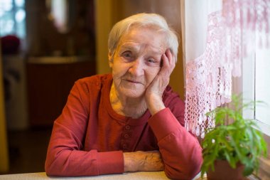 masada oturan yaşlı kadın portresi.