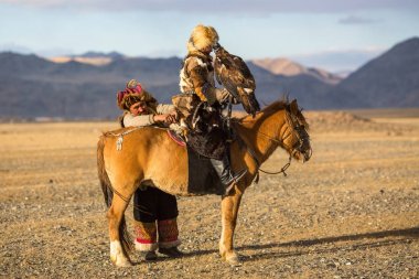 Sagsay, Moğolistan - 28 Eylül 2017: Bayan-Olgii Aymağı dağlarında bir Altın Kartallar ile tavşan kızı avcılık için kazak kartal Hunter (Berkutchi) atı ile öğretir. 