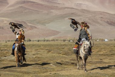 Sagsay, Moğolistan - 28 Eylül 2017: Kartal avcı kuşları ile tavşan içinde çöl Dağ Batı Moğolistan için avcılık genç kızı öğretir..