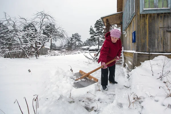 Mujer Mayor Limpia Nieve Cerca Casa —  Fotos de Stock