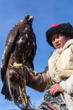 Bayan Ulgii, Moğolistan-Eyl 30, 2017: Kartal avcı ise dağların Batı Moğolistan'da bir altın kartal tutan tavşan için avcılık geleneksel kıyafetleri.