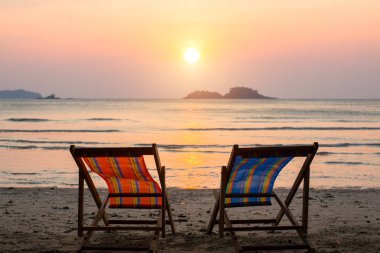 Şaşırtıcı günbatımı, deniz kenarında şezlong.