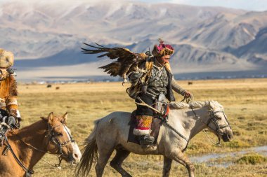 Sagsay, Moğolistan - 28 Eylül 2017: Kartal avcı kuşları ile tavşan içinde çöl Dağ Batı Moğolistan için avcılık genç kızı öğretir..