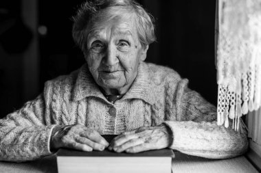 Yaşlı kadın büyük bir kitap ile siyah beyaz portre.