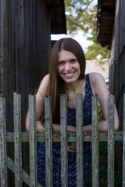 Ahşap çit Köyü yakınındaki uzun kahverengi saçlı genç kadın.