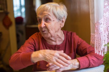 Masada oturan duygusal yaşlı kadın.