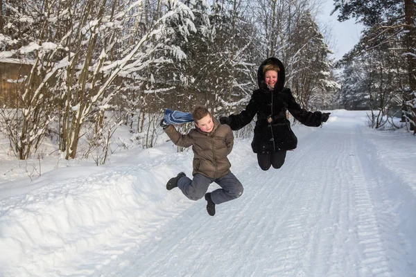 Jonge Vrouw Speelt Met Een Jongetje Een Besneeuwde Winter Park — Stockfoto