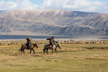 Sagsay, Moğolistan - 28 Eylül 2017: Berkutchi (Kartal avcıları) ise avcılık için bir Altın Kartallar ile tavşan Bayan-Olgii Aymağı dağlarında kolları üzerinde at. 