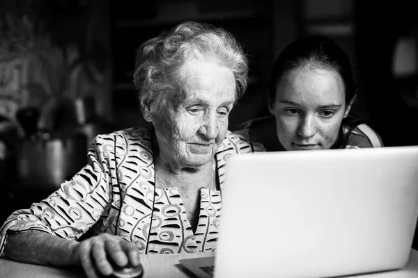 十几岁的女孩教她的祖母打字的笔记本电脑 — 图库照片