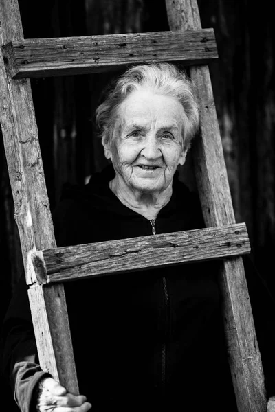 Schwarz Weiß Porträt Einer Älteren Frau Neben Einer Rustikalen Holztreppe — Stockfoto