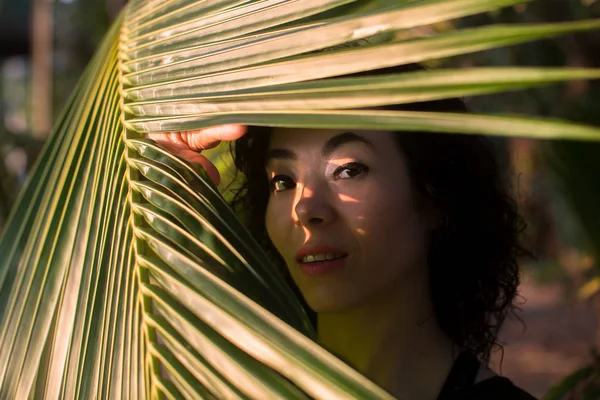 Красивая Азиатская Девушка Смотрит Сквозь Пальмовые Листья — стоковое фото