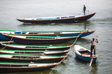 Varanasi, Hindistan - 13 Mar 2018: Boatmen Ganga nehir kıyısında. Varanasi bir Hindistan en önemli hac sitelerin ve Hinduizm 7 kutsal şehirlerden biri.