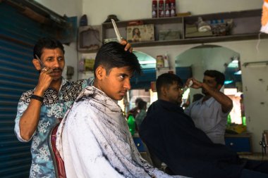 Varanasi, Hindistan - 14 Mar 2018: Kuaför Hacı saç keser. Varanasi, bir saç kesimi Hinduizm arıtma ayin bir tür olarak kabul edilir.