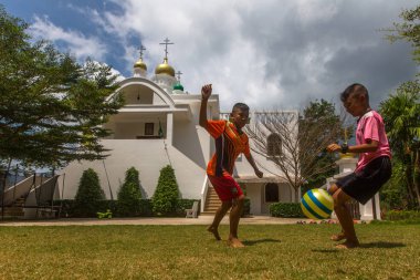 Koh Chang, Tayland - Mar 3, 2018: Tay çocuklar Rus Ortodoks Kilisesi yakınındaki top oynamak. Tayland'da şu anda 10 Ortodoks yerleşim birimleri, Ortodoks nüfus %0,002 tarafından uygulanmaktadır