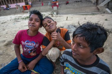 Varanasi, Hindistan - 16 Mar 2018: Kimliği belirsiz Hint sokak çocukları Ganga nehir kıyısında. Efsaneye göre şehrin yaklaşık 5000 yıl önce Tanrı Shiva tarafından kuruldu.