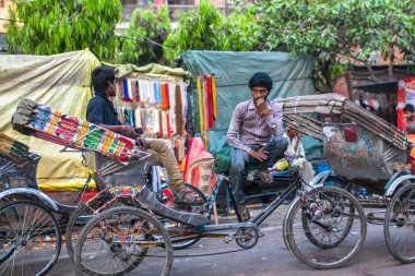 VARANASI, INDIA - MAR 21, 2018: Indian trishaw waiting passengers on the street. According to legends, the city was founded by God Shiva about 5000 years ago. clipart