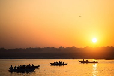 Tekne siluetleri ile muhteşem gün batımı sırasında hacıların kutsal Ganj Nehri, Varanasi, Hindistan.