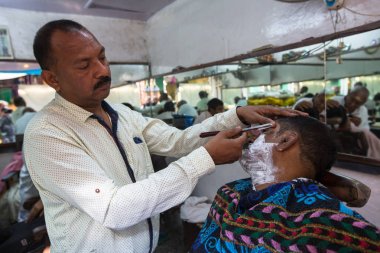 Varanasi, Hindistan - 16 Mar 2018: Kuaför Hacı saç keser. Varanasi, bir saç kesimi Hinduizm arıtma ayin bir tür olarak kabul edilir.