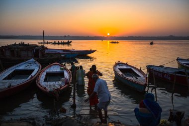Varanasi, Hindistan - 18 Mar 2018: Şafak tekne ile Hacı siluetleri ile Ganj Nehri üzerinde. Efsaneye göre şehrin yaklaşık 5000 yıl önce Tanrı Shiva tarafından kuruldu.