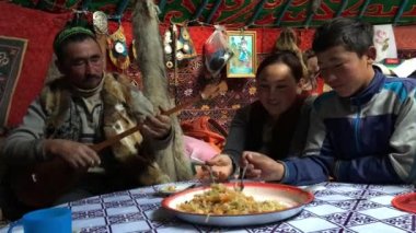 SAGSAI, BAYAN-OLGIY, MONGOLIA - SEP 28, 2017: Kazakh family of hunters with golden eagles inside the mongolian Yurt. In Bayan-Olgii Province is populated mainly by Kazakhs (88,7%)
