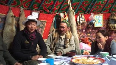 SAGSAI, BAYAN-OLGIY, MONGOLIA - SEP 28, 2017: Kazakh family of hunters with golden eagles inside the mongolian Yurt. In Bayan-Olgii Province is populated mainly by Kazakhs (88,7%)