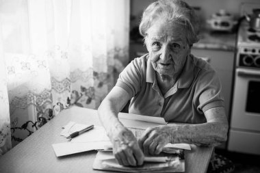 Yaşlı kadın emekli faturaları ödemek yardımcı programları.