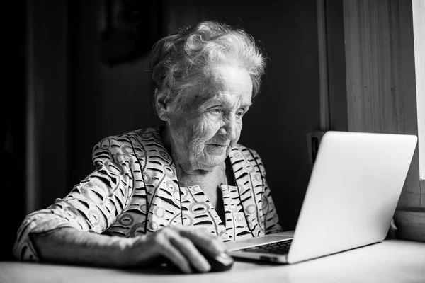 老年妇女在笔记本电脑上工作 — 图库照片