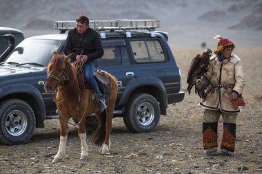 Olgiy, Moğolistan - Eyl 30, 2017: Kazak altın kartal avcı, geleneksel giyim, kuşları Berkutchi Batı Moğolistan ile yıllık Ulusal yarışma sırasında kolunda altın kartal ile.