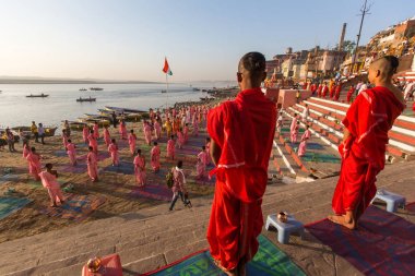Varanasi, Hindistan - 18 Mar 2018: Genç hindu Rahipler şafak Ganj kıyısında karşılamak için bir tören yapmak ve Hint ve bayrağını yükseltmek. Varanasi Hinduizm 7 kutsal şehirlerden biri. 