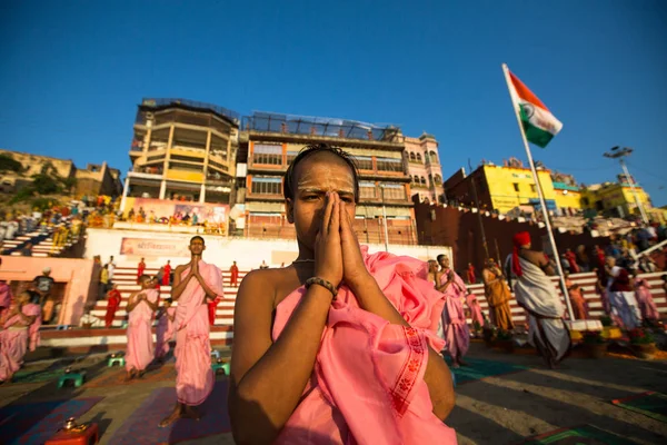 バラナシ インド 2018 若いヒンドゥー教の僧侶は ガンジス河のほとりに夜明けに合わせて式を実施 インドの旗を上げます バラナシはヒンズー教の の神聖な都市の一つ — ストック写真