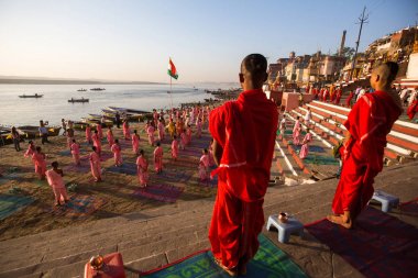 Varanasi, Hindistan - 18 Mar 2018: Genç hindu Rahipler şafak Ganj kıyısında karşılamak için bir tören yapmak ve Hint ve bayrağını yükseltmek. Varanasi Hinduizm 7 kutsal şehirlerden biri. 