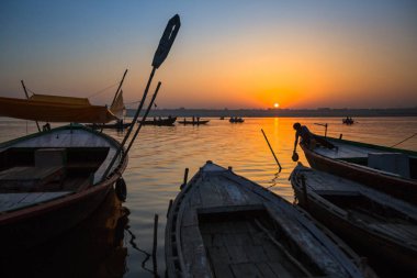 Varanasi, Hindistan - 18 Mar 2018: Şafak tekne ile Hacı siluetleri ile Ganj Nehri üzerinde. Efsaneye göre şehrin yaklaşık 5000 yıl önce Tanrı Shiva tarafından kuruldu.