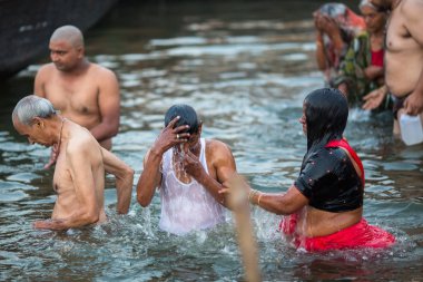 Varanasi, Hindistan - 23 Mar 2018: Hacılar sabahın erken saatlerinde su kutsal Ganj Nehri Dalma. Efsaneye göre şehrin yaklaşık 5000 yıl önce Tanrı Shiva tarafından kuruldu.