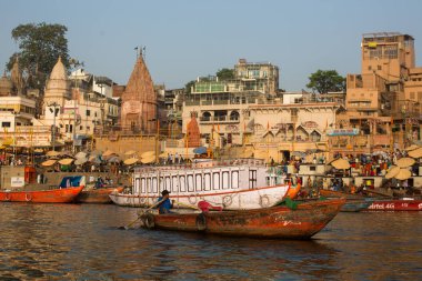 Varanasi, Hindistan - 26 Mar 2018: Bir tekne görünümünden suda Varanasi kıyı boyunca Ganj Nehri üzerinde süzülüyor. Efsaneye göre şehrin yaklaşık 5000 yıl önce Tanrı Shiva tarafından kuruldu.