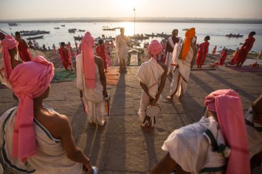 Varanasi, Hindistan - 18 Mar 2018: Genç hindu Rahipler şafak Ganj kıyısında karşılamak için bir tören yapmak ve Hint ve bayrağını yükseltmek. Varanasi Hinduizm 7 kutsal şehirlerden biri. 