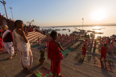 Varanasi, Hindistan - 18 Mar 2018: Genç hindu Rahipler şafak Ganj kıyısında karşılamak için bir tören yapmak ve Hint ve bayrağını yükseltmek. Varanasi Hinduizm 7 kutsal şehirlerden biri. 