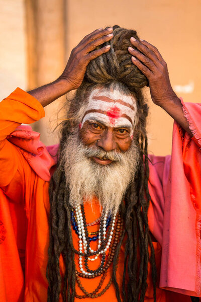 VARANASI, INDIA - MAR 19, 2018: Sadhu or Baba (holy man) on the ghats of Ganges river. Normally a sadhu is a monk, renounced, renounced material enjoyment. In India from 4 to 5 million sadhu.