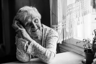 75-80 yaşında yaşlı bir pozitif kadın portresi siyah ve beyaz.