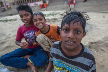 Varanasi, Hindistan - 16 Mar 2018: Kimliği belirsiz Hint sokak çocukları Ganga nehir kıyısında. Efsaneye göre şehrin yaklaşık 5000 yıl önce Tanrı Shiva tarafından kuruldu.