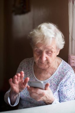 Yaşlı kadın onun elinde bir akıllı telefon ile.