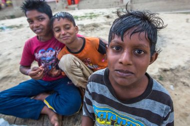 Varanasi, Hindistan - 16 Mar 2018: Kimliği belirsiz Hint sokak çocukları Ganga nehir kıyısında. Efsaneye göre şehrin yaklaşık 5000 yıl önce Tanrı Shiva tarafından kuruldu.