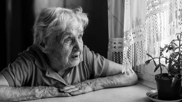Idős Asszony Szomorúan Kinéz Ablakon — Stock Fotó