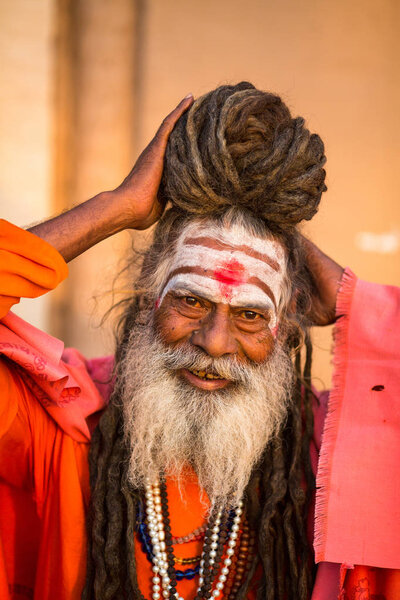 VARANASI, INDIA - MAR 19, 2018: Sadhu or Baba (holy man) on the ghats of Ganges river. Normally a sadhu is a monk, renounced, renounced material enjoyment. In India from 4 to 5 million sadhu.