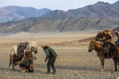 Sagsay, Moğolistan - 28 Eylül 2017: Berkutchi kartal avcı ile hare avlar, Batı Moğolistan çöl dağlar sırasında altın kartal.