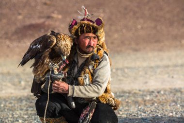 Sagsay, Moğolistan - 28 Eylül 2017: Berkutchi kartal avcı ile hare avlar, Batı Moğolistan çöl dağlar sırasında altın kartal.