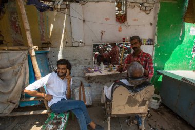 Varanasi, Hindistan - 14 Mar 2018: Kuaför Hacı saç keser. Varanasi, bir saç kesimi Hinduizm arıtma ayin bir tür olarak kabul edilir.