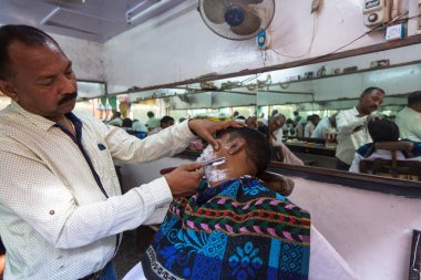 Varanasi, Hindistan - 16 Mar 2018: Kuaför Hacı saç keser. Varanasi, bir saç kesimi Hinduizm arıtma ayin bir tür olarak kabul edilir.