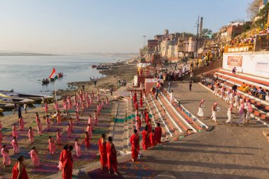 Varanasi, Hindistan - 18 Mar 2018: Genç hindu Rahipler şafak Ganj kıyısında karşılamak için bir tören yapmak ve Hint ve bayrağını yükseltmek. Varanasi Hinduizm 7 kutsal şehirlerden biri. 